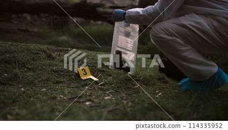 Crime scene, gun and investigator with evidence outdoor for forensics, analysis and investigation in forest or nature. Person hands with weapon, ppe and inspection or police search for clues in woods Crime scene, gun and investigator with evidence outdoor for forensics, analysis and investigation in forest or nature. Person hands with weapon, ppe and inspection or police search for clues in woods 114335952