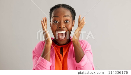 Excited, black woman and surprise with good news for winning, celebration or prize on a gray studio background. Portrait of African female person with smile for lucky draw or lottery on mockup space Excited, black woman and surprise with good news for winning, celebration or prize on a gray studio background. Portrait of African female person with smile for lucky draw or lottery on mockup space 114336176
