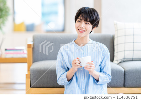 A woman relaxing in the living room. 114336751