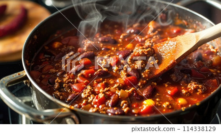Hearty beef chili with beans and tomatoes garnished with fresh herbs. Close-up food photography. Hearty beef chili with beans and tomatoes garnished with fresh herbs. Close-up food photography. 114338129