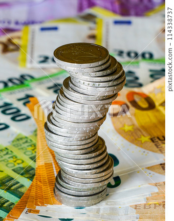 Unstable stack of euro coins on the euro banknotes background, unstable future balance concept Unstable stack of euro coins on the euro banknotes background, unstable future balance concept 114338737
