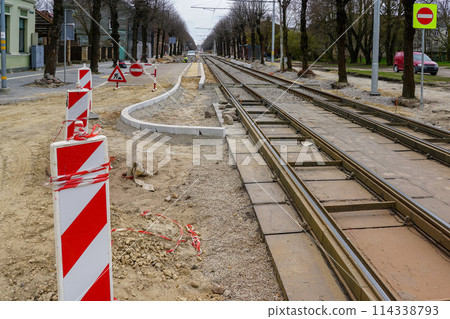 Unfinished construction of a modern low-floor tram stop and replacement of rails on a city street 114338793