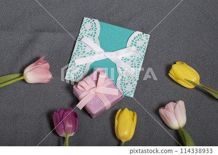 Bouquet of tulips of different colors on a gray background. Next greeting card and gift wrapped. Bouquet of tulips of different colors on a gray background. Next greeting card and gift wrapped. 114338933