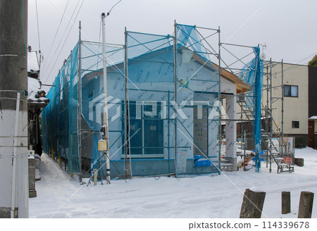 Image of a new building: A snowy day, a single-story house under construction 114339678