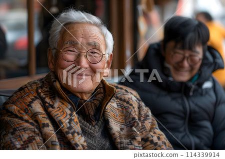 Senior Asian man smiling with family in a cozy setting Senior Asian man smiling with family in a cozy setting 114339914