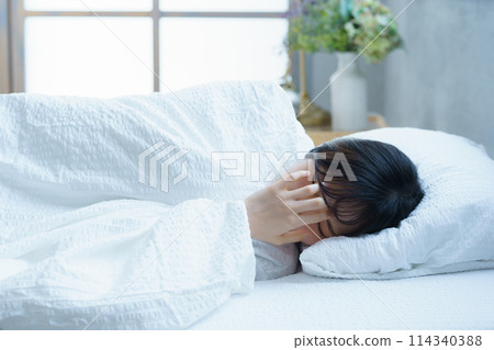 Young woman having difficulty waking up in the morning Young woman having difficulty waking up in the morning 114340388