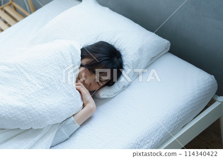 Young woman having difficulty waking up in the morning Young woman having difficulty waking up in the morning 114340422