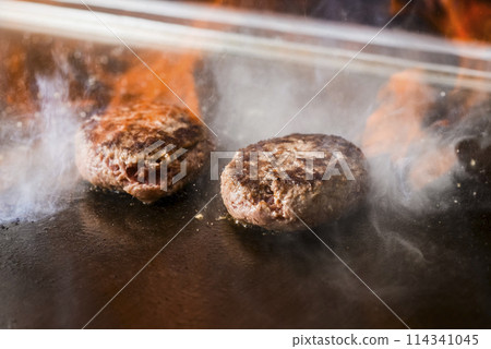 Hamburg steak on a hot plate being flambéed 114341045