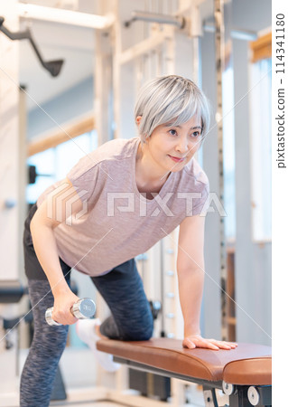 Middle-aged woman doing muscle training at the gym 114341180