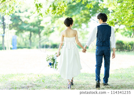 A bride and groom holding hands 114341235
