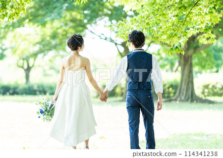 Bride and groom walking hand in hand 114341238
