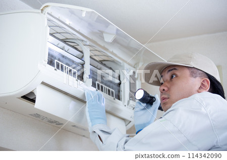A young Japanese man working on an air conditioner repair and inspection A young Japanese man working on an air conditioner repair and inspection 114342090