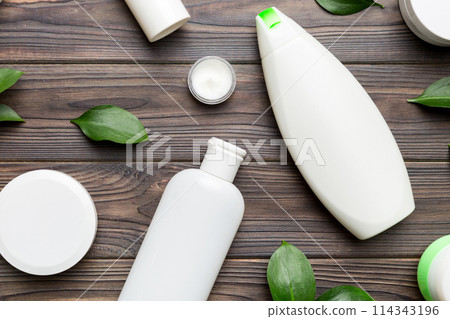 Organic cosmetic products with green leaves on wooden background. Flat lay 114343196