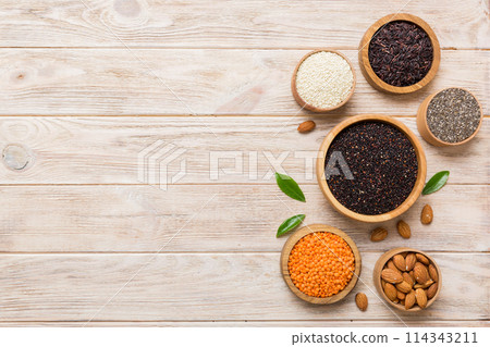 Various superfoods in smal bowl on colored background. Superfood as rice, chia, quinoa, lentils, nuts, sesame seeds, almonds. top view copy space Various superfoods in smal bowl on colored background. Superfood as rice, chia, quinoa, lentils, nuts, sesame seeds, almonds. top view copy space 114343211