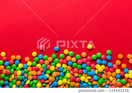 Mixed collection of colorful candy, on colored background. Flat lay, top view. frame of colorful chocolate coated candy 114343256