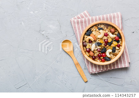 Cooking a wholesome breakfast. Granola with Various dried fruits and nuts in a bowl. The concept of a healthy dessert. Flat lay, top view with copy space 114343257
