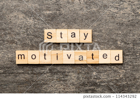 Stay motivated word written on wood block. Stay motivated text on cement table for your desing, concept Stay motivated word written on wood block. Stay motivated text on cement table for your desing, concept 114343292