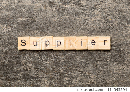 SUPPLIER word written on wood block. SUPPLIER text on cement table for your desing, concept 114343294