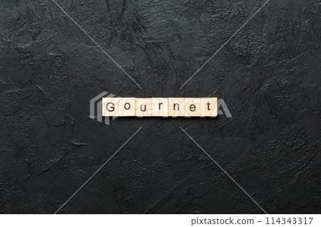 gourmet word written on wood block. gourmet text on cement table for your desing, concept 114343317