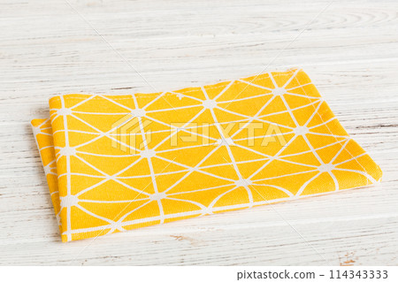 top view with yellow empty kitchen napkin isolated on table background. Folded cloth for mockup with copy space, Flat lay. Minimal style 114343333