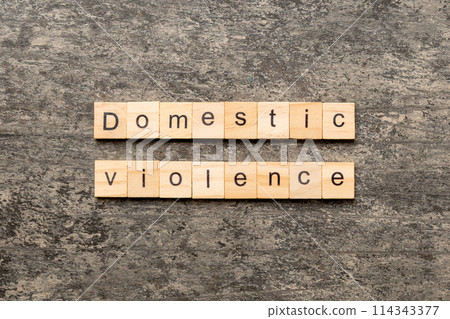 Domestic violence word written on wood block. Domestic violence text on cement table for your desing, Top view concept Domestic violence word written on wood block. Domestic violence text on cement table for your desing, Top view concept 114343377