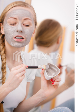 Woman with grey clay mud mask on her face Woman with grey clay mud mask on her face 114343578