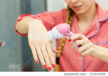 Woman holding facial cleansing brush Woman holding facial cleansing brush 114343580
