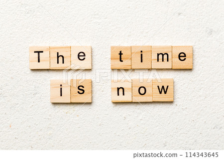 the time is now word written on wood block. the time is now text on table, concept 114343645