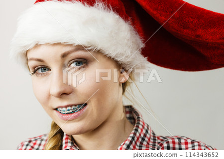 Happy woman wearing Santa Claus helper hat 114343652