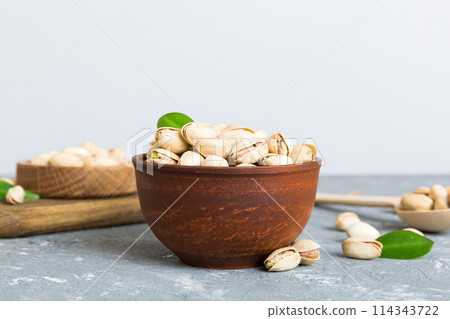Fresh healthy Pistachios in bowl on colored table background. Top view Healthy eating concept. Super foods Fresh healthy Pistachios in bowl on colored table background. Top view Healthy eating concept. Super foods 114343722