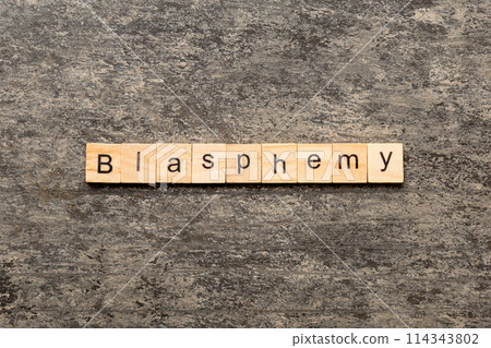 BLASPHEMY word written on wood block. BLASPHEMY text on cement table for your desing, concept 114343802