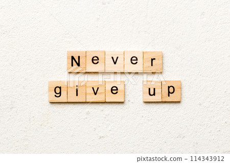 never give up word written on wood block. never give up text on cement table for your desing, concept 114343912
