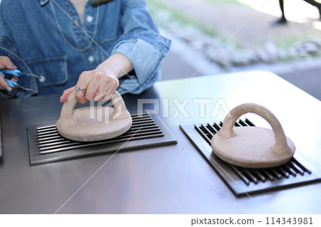 A woman experiencing hand-baking Soka Senbei rice crackers 114343981