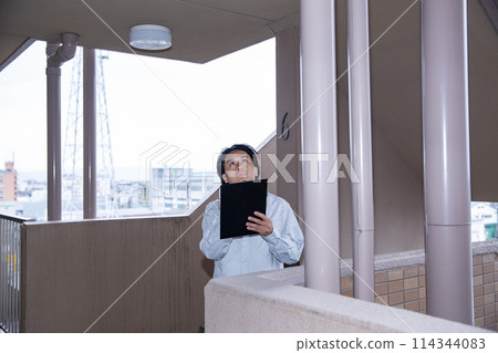 A man inspecting a building 114344083