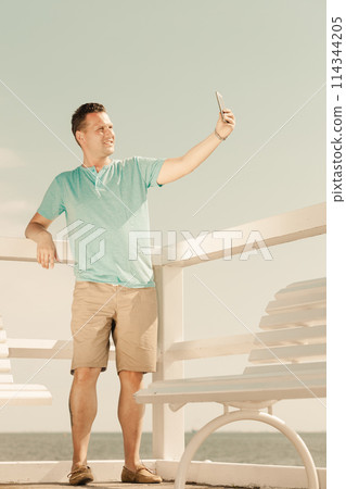 Happy man taking self picture with smartphone Happy man taking self picture with smartphone 114344205