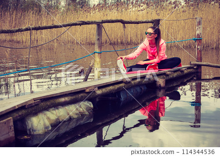 Girl training in sporty clothes on lake shore 114344536