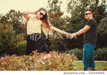 Cheerful girl holding hands in park. 114344800