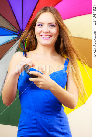 Woman in summer dress holds colorful umbrella 114344827