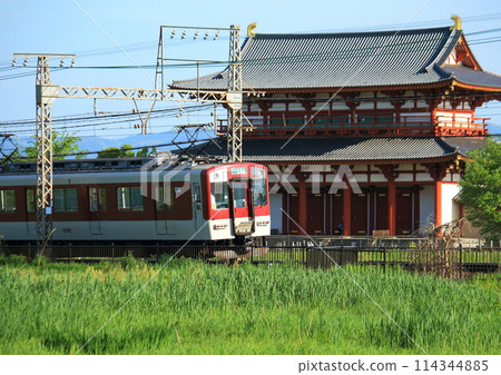 A Kintetsu Nara Line train runs in front of the World Heritage Nara Heijo Palace Suzakumon Gate 114344885