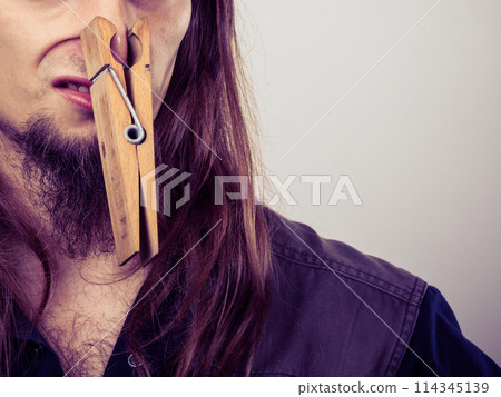Man with clogged nose by clothespin 114345139