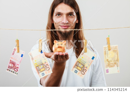 Man holding moneybox piggybank Man holding moneybox piggybank 114345214