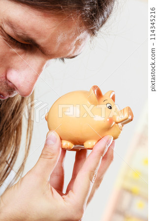 Man holding moneybox piggybank 114345216