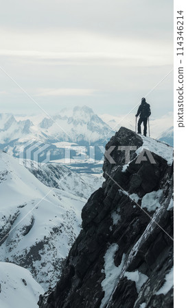 Man Standing on Snow Covered Mountain 114346214