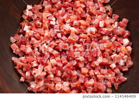 Rustic bowl of diced Spanish jamon meat. Cured serrano ham close up. Typical mediterranean ingredient 114346409
