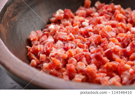 Traditional Spanish jamon cubes in wooden bowl close up. Meat cooking ingredient. 114346410
