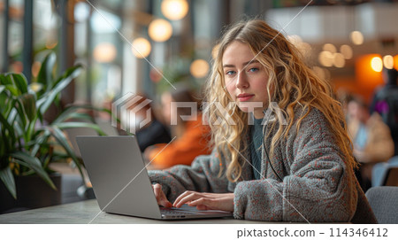 Focused Woman Working on Laptop at Cozy Cafe 114346412