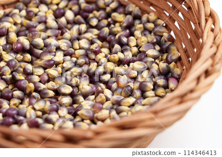 Organic dried blue corn kernels in rattan wooden bowl close up. Dry Mexican Hopi maize grains 114346413