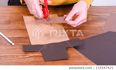 Step by step. Teacher guides online class through making a paper puppet from a brown bag, creatively using a wooden surface as a workspace. Step by step. Teacher guides online class through making a paper puppet from a brown bag, creatively using a wooden surface as a workspace. 114347425