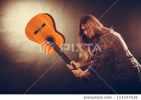 Rock musician destroys his guitar. 114347426