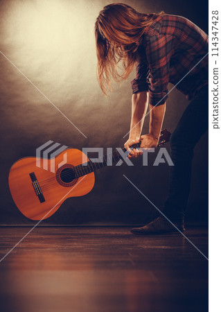 Rock musician destroys his guitar. 114347428